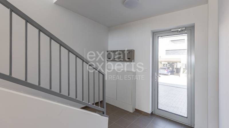 Entrance hallway in a 4-room apartment with glass doors and a staircase.