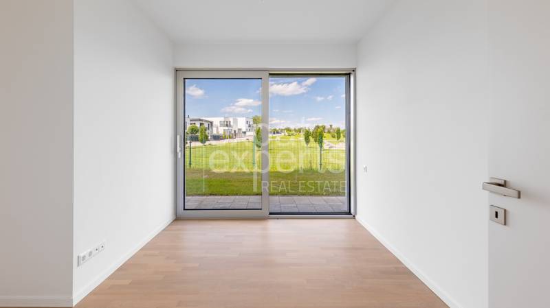 A room in a 4-room apartment with a wooden decor floor and a view of the garden.