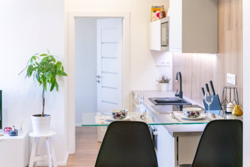 Interior of a 2-room apartment with a kitchen counter and decorations, floor with wooden decor.