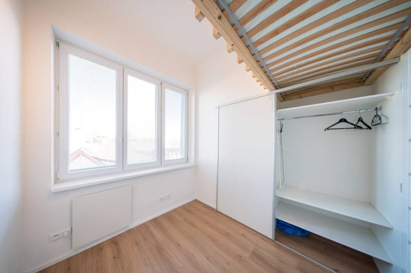 A bright room in a 2-room apartment with large windows and a built-in wardrobe.