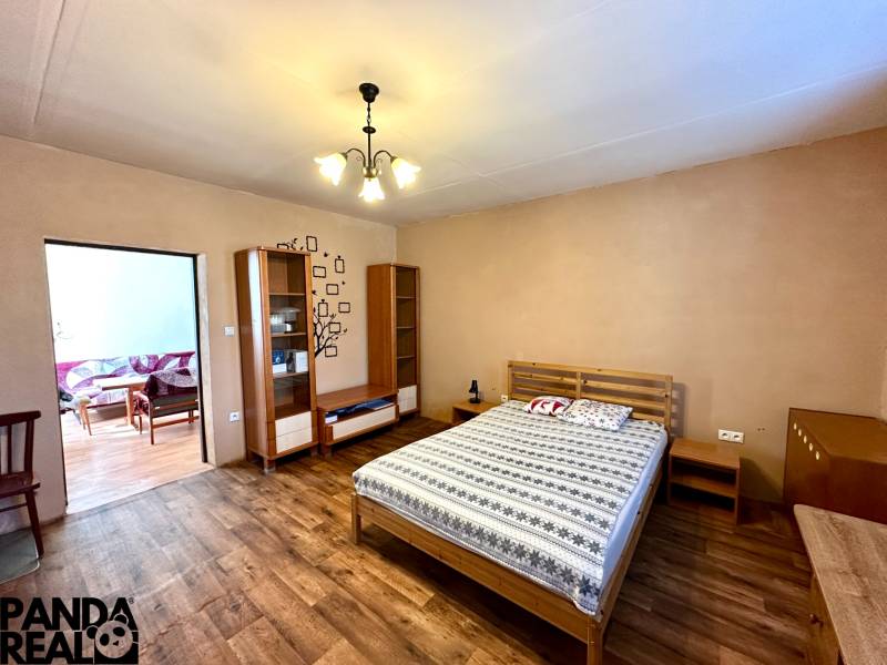 Bedroom in a family house with a bed and a wooden decor floor.