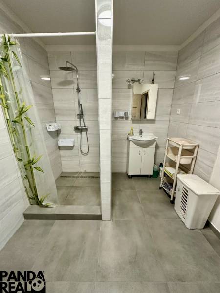 A bathroom in a family house with a large shower and a mirror above the sink.