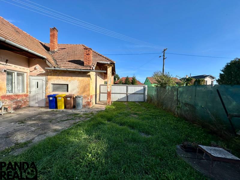 Family house in Ludanice with a lawn and a concrete terrace in the backyard.