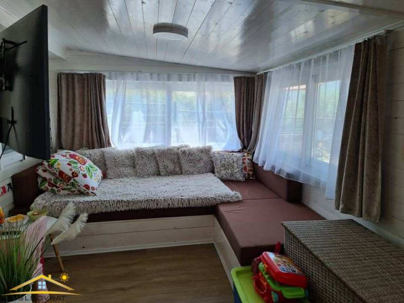 A room in unique real estate with comfortable seating and a floor with wood decor.