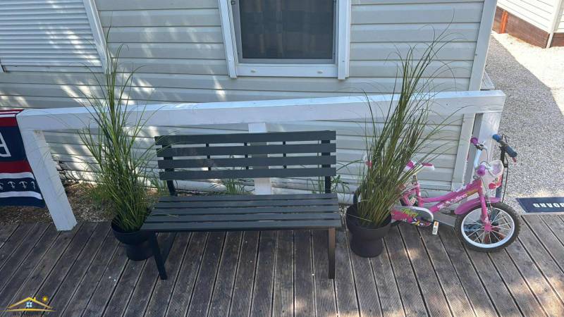 Bench, flower pots, bicycle on the floor with wooden decor at Unusual Properties.