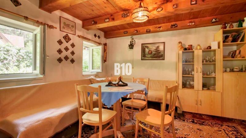 Traditional cottage with a wooden ceiling, rustic furniture, and a cozy seating area around the table.