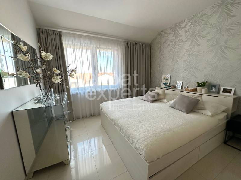 A bright bedroom in a 3-room apartment with decorative pillows and a large mirror.