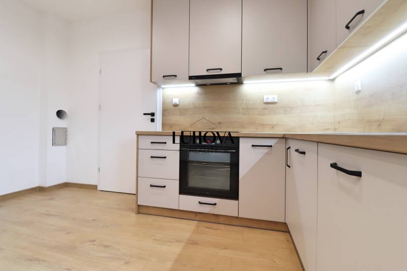 A kitchen in a family house with a wooden decor floor and built-in appliance.