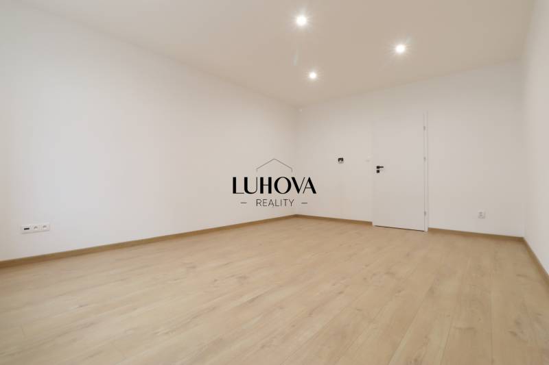 Spacious bright room with wood-patterned flooring in a family house.