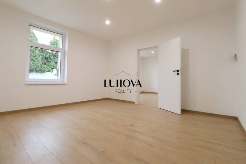 A room in a family house with a window and a wooden decor floor.