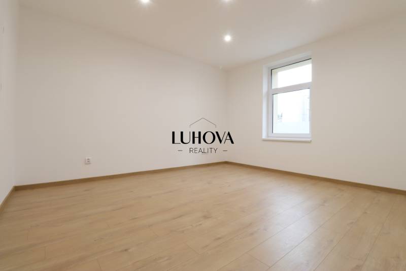 A spacious room with a wooden decor floor in a family house.