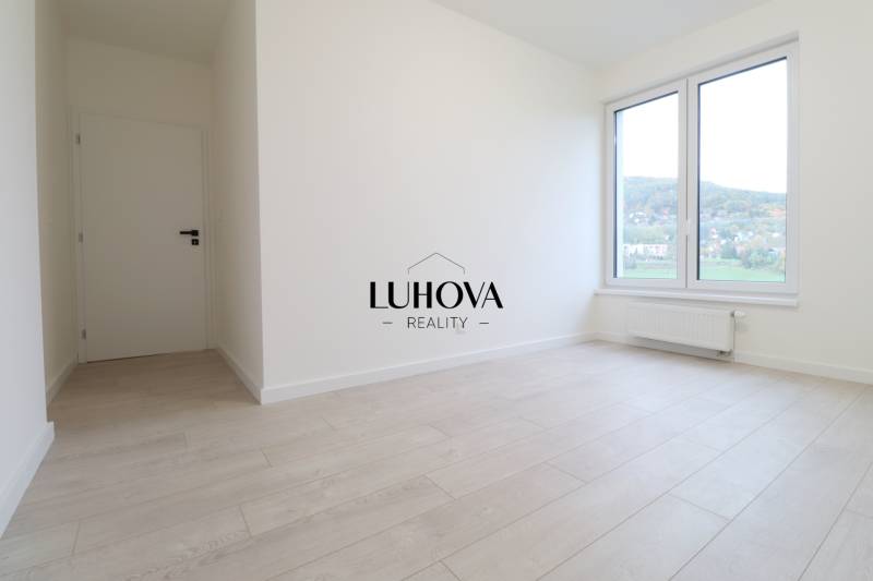 A bright room with white walls and a floor with a wood decor in a 4-room apartment.