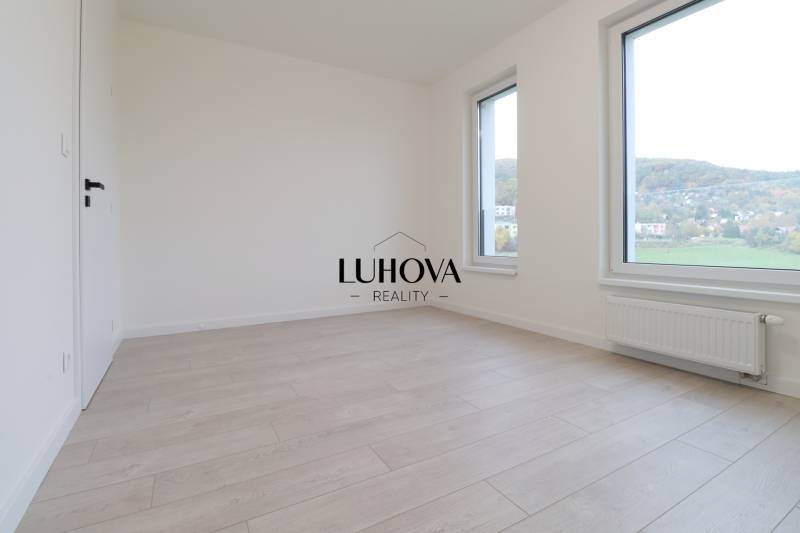 A spacious room in a 4-room apartment with a wood-patterned floor and large windows.