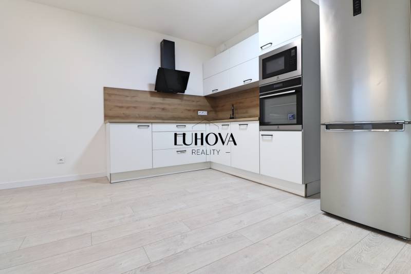 A kitchen with built-in appliances and a wooden decor floor in a 4-room apartment.