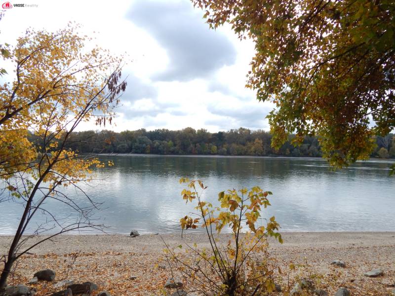 Autumn by the river in Radvaň nad Dunajom, surrounded by colorful trees and a pebble beach.