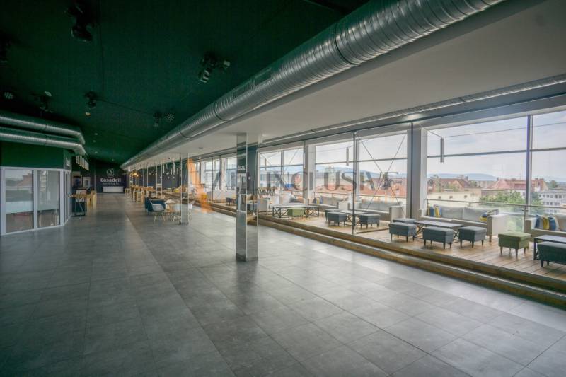 Spacious gastro spaces with glazing and wooden decor flooring offer a view of the city.