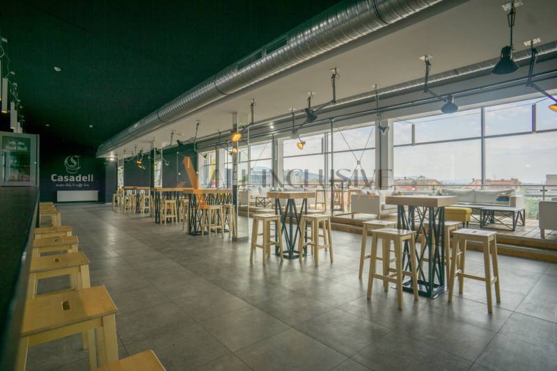 Interior of gastro spaces with high tables and large windows.