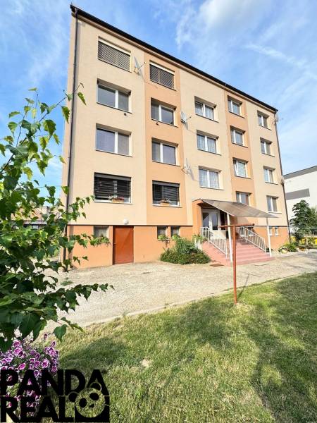 A four-story building surrounded by greenery in Horné Obdokovce, ideal for a 4-room apartment.