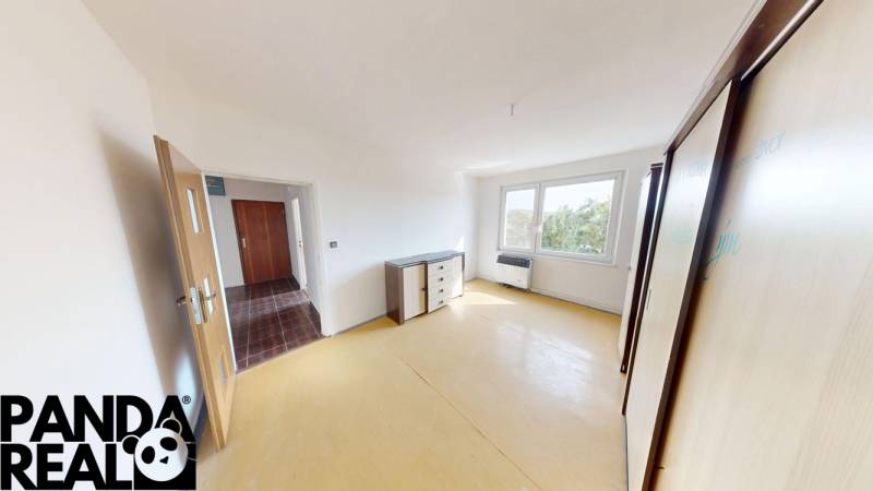 A room with light furniture and a large window in a 4-room apartment.