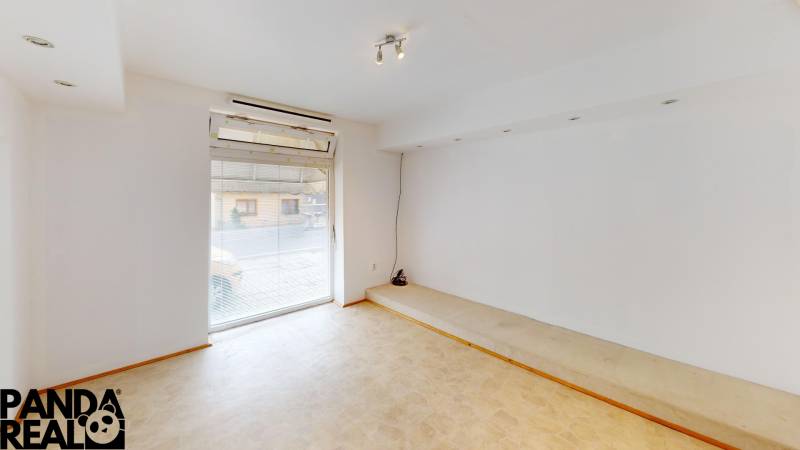 A bright room in a family house with a large window and a light floor.