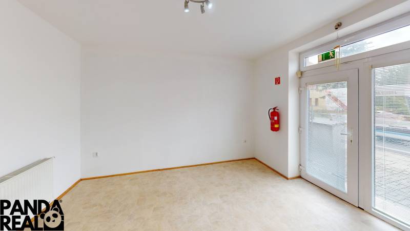 Interior of a family house with a wooden decor floor, a fire extinguisher, and glass doors.