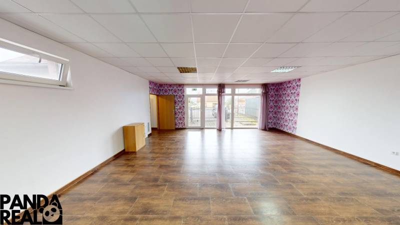 A spacious room in a family house with a wooden decor floor and wallpaper.