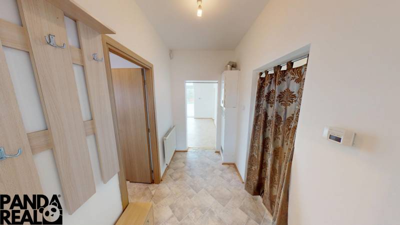 A hallway with a wall hanger and a decorative curtain in a family house.