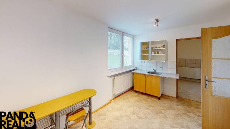 A kitchen in a family house with a sink, a bar counter, and a window.
