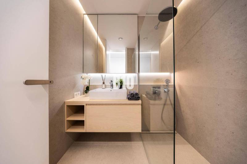 Bathroom with a mirror, shower, and wooden decor in a 3-room apartment.