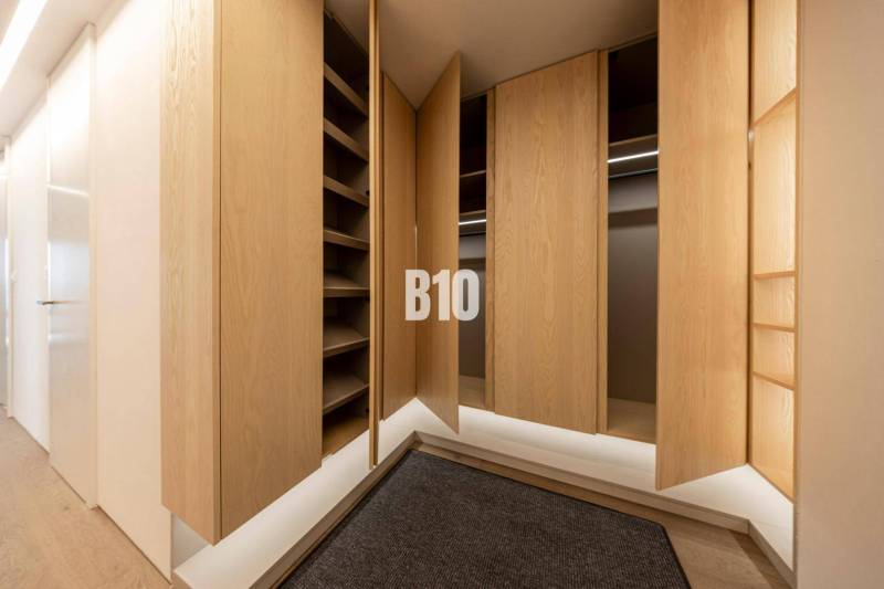 A wardrobe with wooden doors and a floor with a wooden decor in a 3-room apartment.