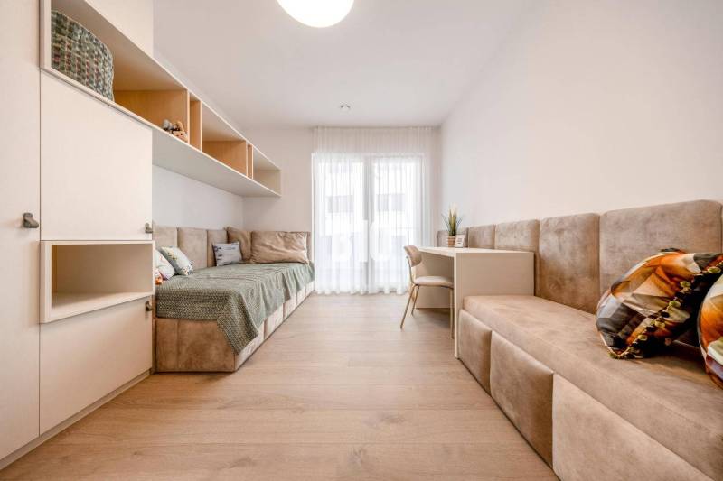 Bright room in a 3-bedroom apartment with wood-patterned flooring and comfortable furniture.