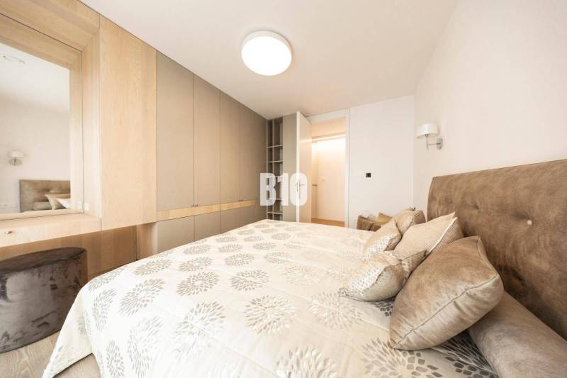 Bedroom in a 3-room apartment with storage spaces and a bed with patterned textiles.