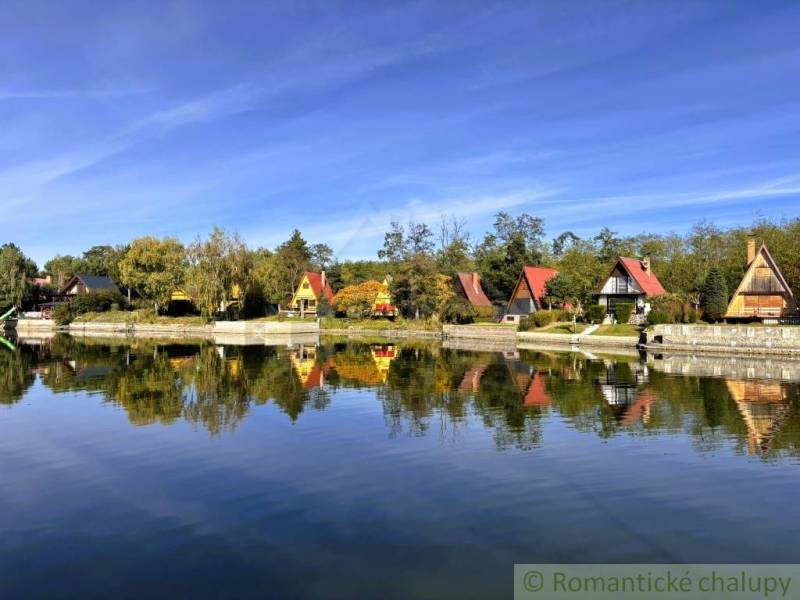 A cottage in Malé Leváre with a view of the lake and sky with reflections.