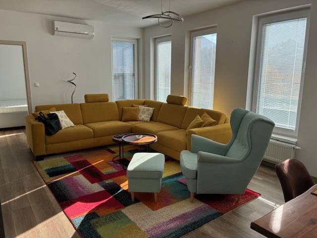 A colorful carpet complements the comfortable sofa and armchair in the 3-room apartment.