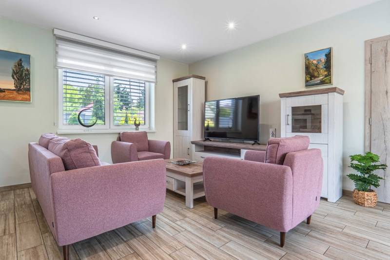A living room with pink sofas and a television in a family house.