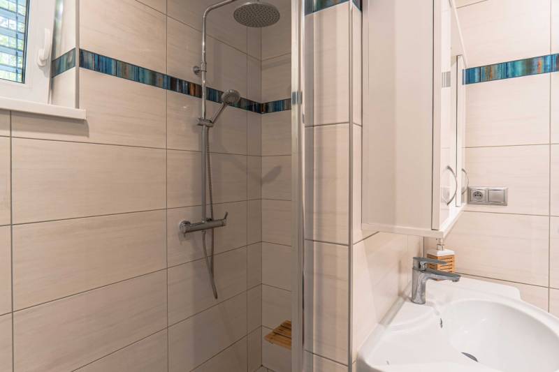 Bathroom with a shower and sink in a family house.