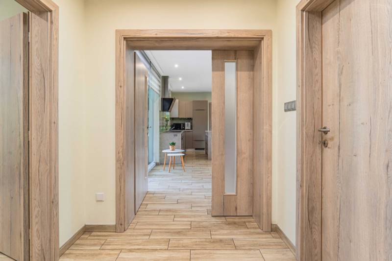 Hallway in a family house with wooden doors and translucent panels.