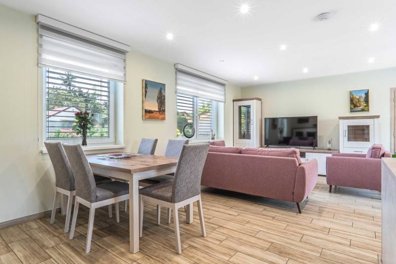 Living room in a family house with a sofa, television, and dining table.