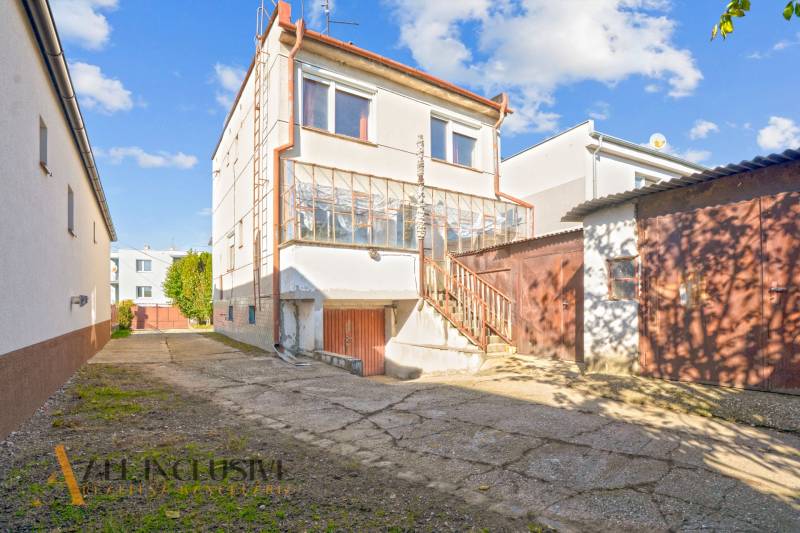 A family house in Veľká Mača with a glazed veranda and an adjacent building in the yard.