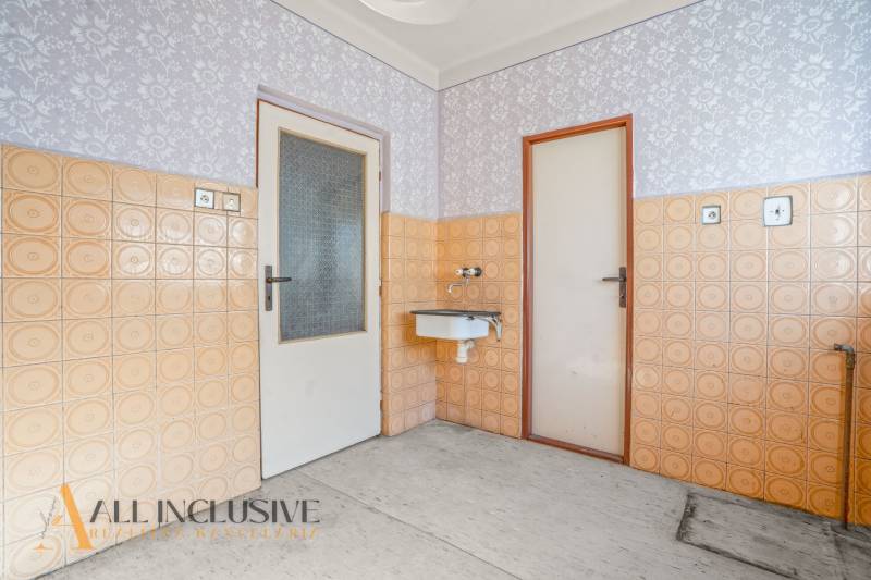 Interior with a sink, tiles, and doors in a family house.