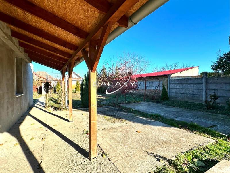 A family house in Horné Saliby with a terrace and a garden surrounded by a fence.