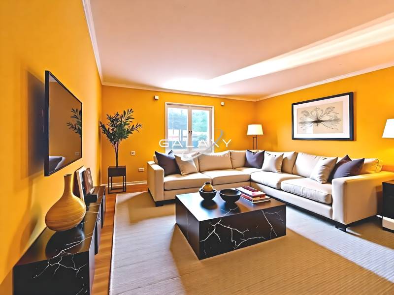 Living room with a sofa, television, tables, and decorations in a family house.