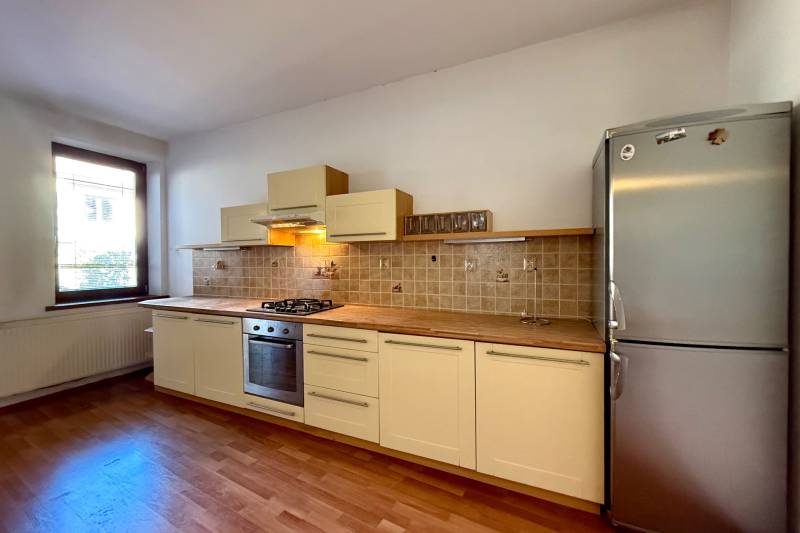 A kitchen in a family house with a wooden decor floor and a stainless steel refrigerator.