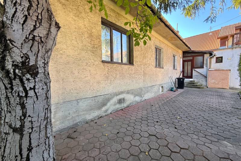 A family house on Prostredná Street in Svätý Jur with a paved yard and a tree.