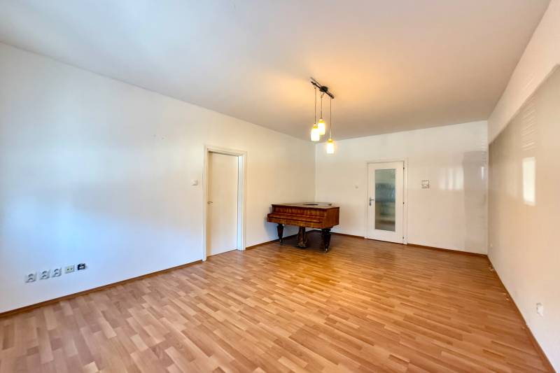 Living room in a family house with a piano and a wooden decor floor.