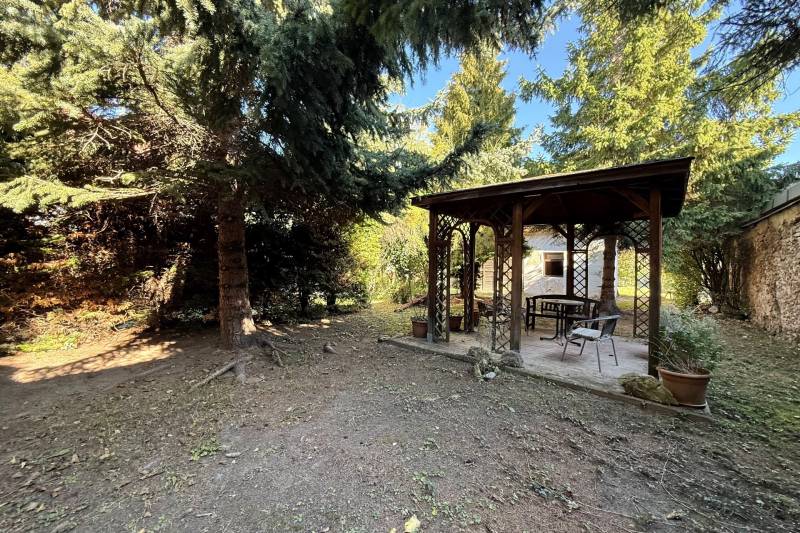 The garden of a family house on Prostredná Street in Svätý Jur with a gazebo among the trees.