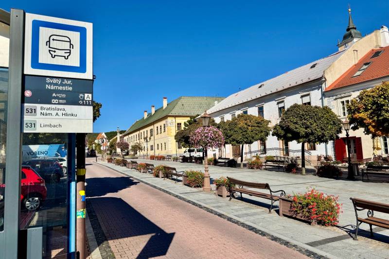 Bus stop in Svätý Jur on the Square with surrounding pedestrian zone and historical buildings.