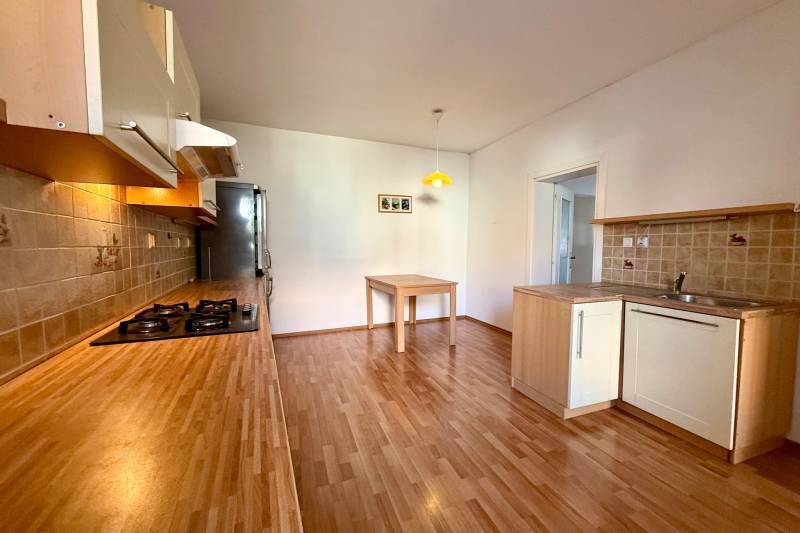 A kitchen in a family house with a wooden decor floor and a wooden kitchen unit.