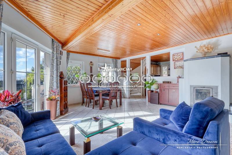 Living room in a family house with a fireplace, blue sofa, and dining table.