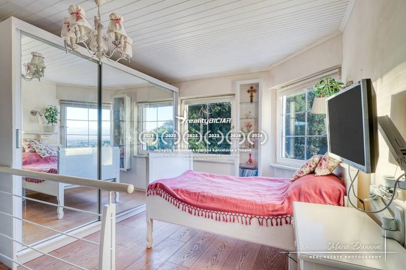 Bright room in a family house with a bed, mirror, and wooden floor decor.